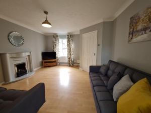 ein Wohnzimmer mit Couch und Kamin in der Unterkunft 3 Bed House with Garage, NR BPW & Brecon Beacons National Park in Cefn-coed-y-cymmer