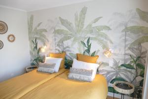 1 dormitorio con 1 cama con plantas en la pared en Les Agapanthes, en Camphin-en-Pévèle