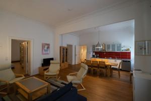 ein Wohnzimmer mit einem Sofa und einem Tisch sowie eine Küche in der Unterkunft Großes Apartment in zentraler Lage in Berlin