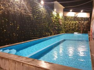 a swimming pool in a backyard with a fence at Hotel Lereng Bromo in Pasuruan