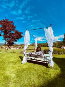 eine Person, die in einer Schaukel auf einem Feld liegt in der Unterkunft Landhaus am Schneewittchenberg in Sonthofen