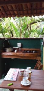 una mesa de madera con tazas encima en Pousada Aldeia de Morere, en Moreré