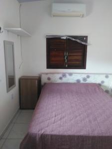 - une chambre avec un lit et une couverture violette dans l'établissement Apartamento a 100 mts da praia, no centro de Pipa, à Pipa