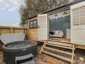 a tiny house with a hot tub in a yard at Honeysuckle Hut, Myrtle Farm in Bristol