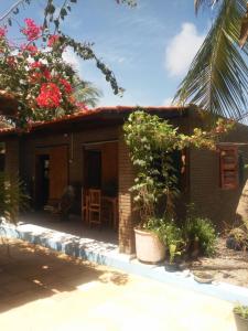 une petite maison avec une table et des chaises devant elle dans l'établissement Casa das Gaúchas, à Canoa Quebrada