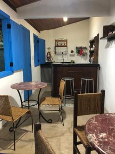 a room with tables and chairs and a kitchen at Vila Glaura in Glaura