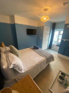 um quarto com uma cama grande e uma mesa em Tegfan -The Anglesey Townhouse em Caernarfon