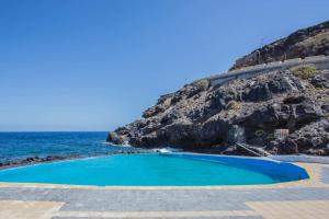 a swimming pool next to the ocean at Casa el Mar apartamento El Faro in Güimar