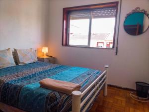 um quarto com uma cama com uma janela e um espelho em Enjoy Braga Estação - Charming Bedrooms in the Historic Center em Braga