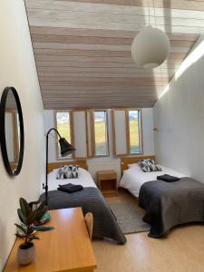 1 dormitorio con 2 camas, mesa y algunas ventanas en Hótel Skálholt en Skálholt
