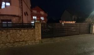 una cerca frente a un edificio por la noche en APARTMANI MIA VUKSANOVIC, en Cetinje