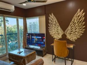 a living room with a tv with wings on the wall at OSI Apartments Bandra West in Mumbai