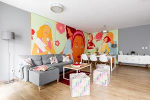 uma sala de estar com um sofá e uma pintura na parede em Apartments Kremer Cracow em Cracóvia