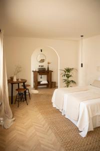 a white bedroom with a bed and a table at San Felipe Suites in Puerto de la Cruz