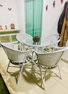 una mesa de cristal y sillas en una habitación en vilage em guarajuba bahia, en Salvador