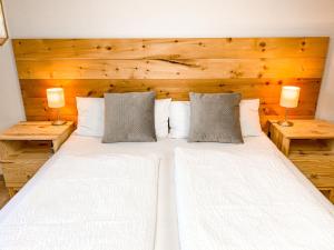 ein Schlafzimmer mit einem großen weißen Bett mit zwei Lampen in der Unterkunft Haus Traun-Ufer in Bad Ischl