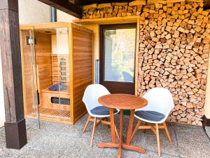 un tavolo e quattro sedie seduti accanto a un muro di legno di Haus Traun-Ufer a Bad Ischl