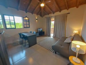una sala de estar con un sofá y una mesa en Cepilho - Flat com cozinha, 50mts da Praia, Churr, Piscina, WiFi eficiente, Netflix, en Paraty