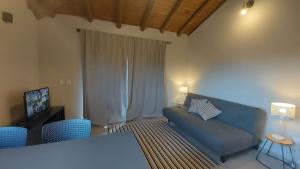 Una sala de estar con un sofá azul y sillas azules. en Cepilho - Flat com cozinha, 50mts da Praia, Churr, Piscina, WiFi eficiente, Netflix, en Paraty