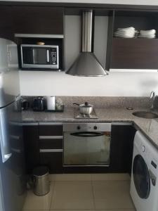 een keuken met een magnetron en een fornuis top oven bij Departamento moderno con cochera en lomas de Zamora in Lomas de Zamora