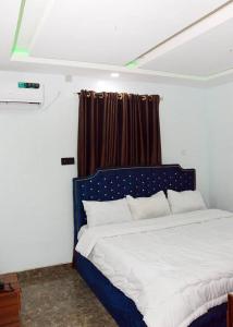 a bedroom with a blue and white bed with a window at Lords&ladies suites in Lagos