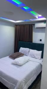 1 dormitorio con cama blanca y techo azul en Lords&ladies suites, en Lagos