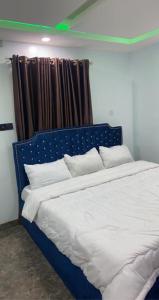 a bedroom with a blue bed with white pillows at Lords&ladies suites in Lagos