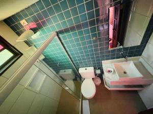 uma casa de banho com um WC cor-de-rosa e um lavatório. em Pousada Tarumim em Vale do Capão
