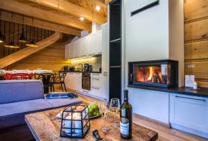a living room with a bottle of wine on a table at Etiuda Zakopane in Zakopane