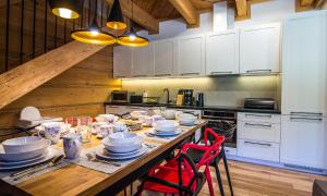 a kitchen with a wooden table with dishes on it at Etiuda Zakopane in Zakopane +65 photos