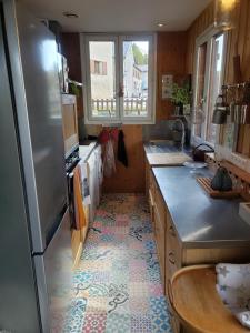 a kitchen with a refrigerator and a tile floor at Chalet le 22 Agniéres in Le Dévoluy
