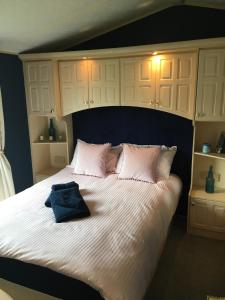 a bedroom with a large white bed with pink pillows at Willerby in Leysdown-on-Sea