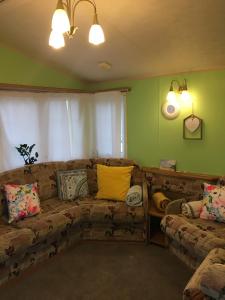 a living room with a couch with pillows on it at Willerby in Leysdown-on-Sea