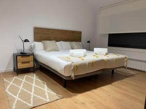 sypialnia z dużym łóżkiem z drewnianym zagłówkiem w obiekcie Oktheway Areal Terrace w mieście Oleiros