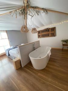 a large bathroom with a tub and a bed at Albergue Jakue in Puente la Reina
