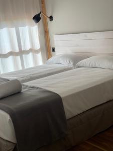2 nebeneinander sitzende Betten in einem Schlafzimmer in der Unterkunft Albergue Jakue in Puente la Reina