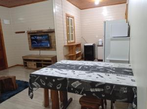 uma cozinha com uma mesa e um frigorífico branco em A Casa é Sua! em Urubici