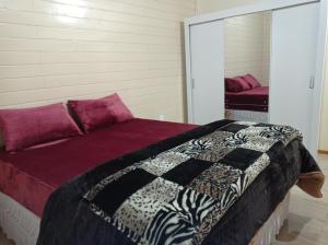 a bedroom with a bed and a mirror at A Casa é Sua! in Urubici