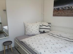 ein kleines Schlafzimmer mit einem Bett und einem Spiegel in der Unterkunft Steinmarner Bude 3 in Cuxhaven