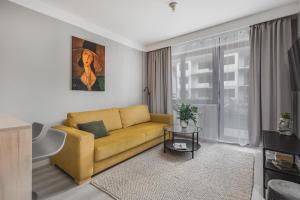 a living room with a yellow couch and a window at TS Nowe Miasto in Szczecin