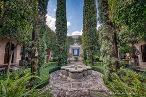 un jardin avec une fontaine au milieu dans l'établissement San Rafael Hotel, à Antigua Guatemala