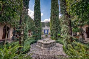 einen Garten mit einem Brunnen in der Mitte in der Unterkunft San Rafael Hotel in Antigua Guatemala