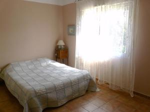 a bedroom with a bed and a window with curtains at Un coin de campagne à 4km de la mer pour 4 à 6 personnes in Portiragnes