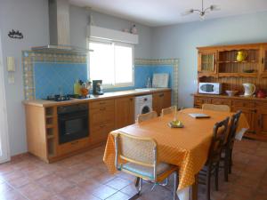 uma cozinha com uma mesa e uma mesa e cadeiras em Un coin de campagne à 4km de la mer pour 4 à 6 personnes em Portiragnes