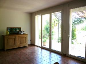 an empty living room with sliding glass doors at Un coin de campagne à 4km de la mer pour 4 à 6 personnes in Portiragnes