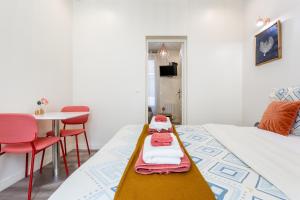 Zimmer mit 2 Betten, einem Tisch und Stühlen in der Unterkunft StayLib - Chic and Cosy 2 rooms porte de Montmartre in Saint-Ouen