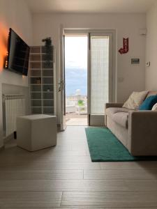 uma sala de estar com um sofá e uma porta de vidro deslizante em SUNSET SUITE em Capoliveri