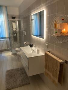 un bagno con lavandino, water e specchio di SUNSET SUITE a Capoliveri