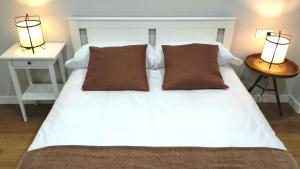 a white bed with two night stands and two lamps at VuT BALBOA APARTAMENTO in Salamanca