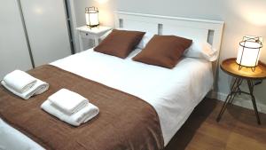 a bedroom with a bed with two towels on it at VuT BALBOA APARTAMENTO in Salamanca